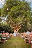 Guests enjoying a festive outdoor wedding meal under elegant canopy lights.