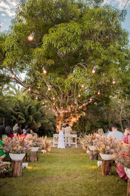 An intimate wedding ceremony under twinkling fairy lights with smiling guests.