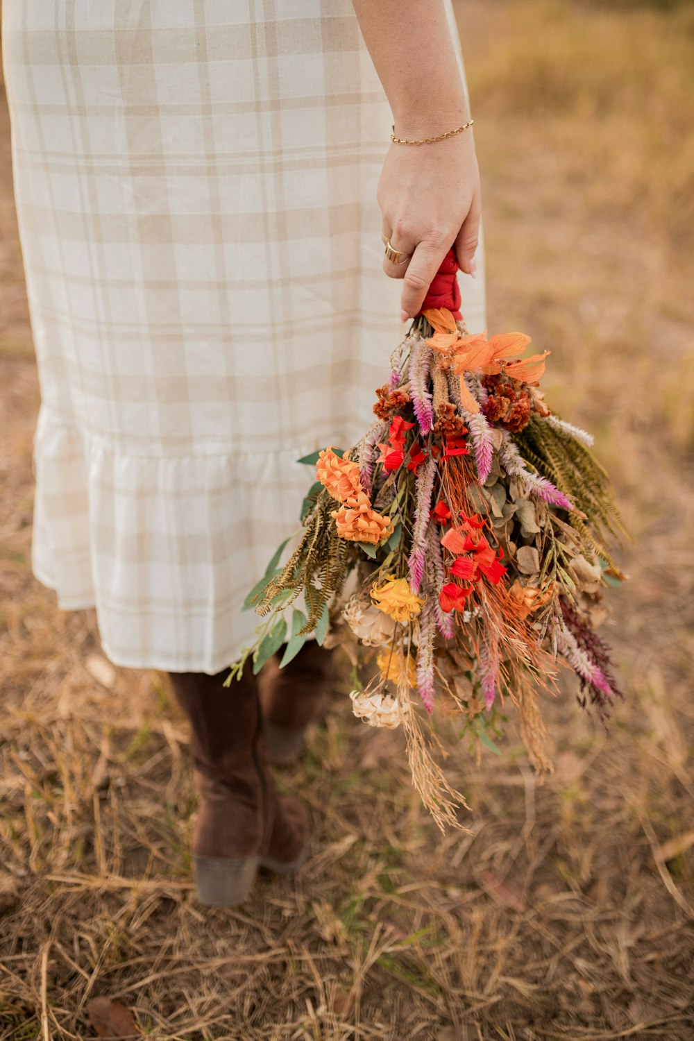 a woman in a dress holding a bouquet of flowers