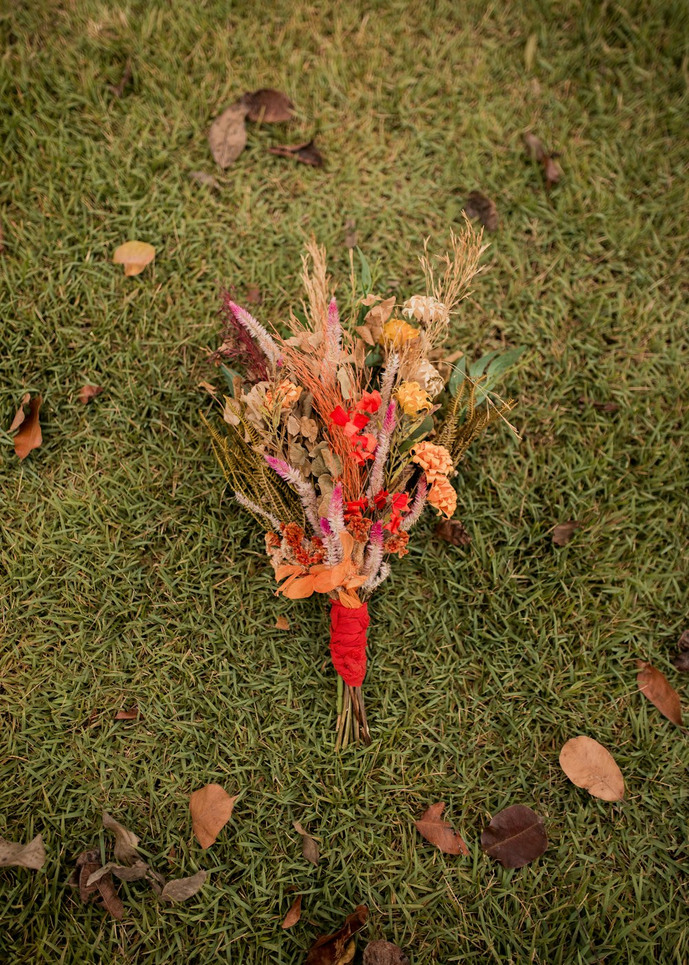 a bouquet of flowers on the ground in the grass