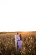 Golden hour shot capturing a couple embracing in a field.