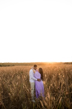 Golden hour shot capturing a couple embracing in a field.