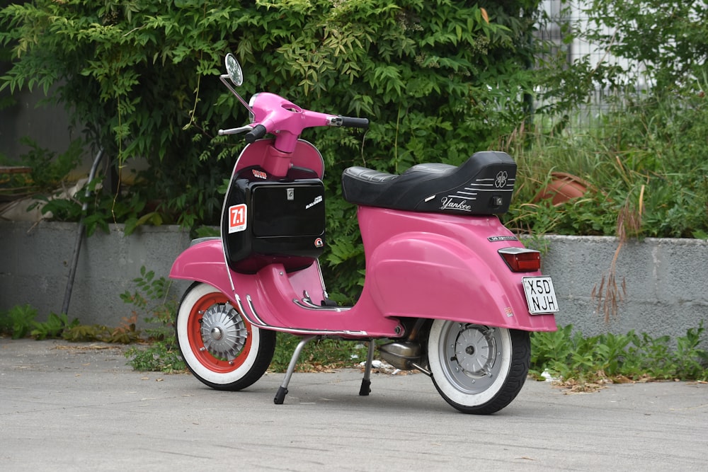 a pink scooter parked on the side of the road