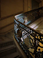 Grand staircase with ornate iron railings and polished marble steps inside a premium estate.