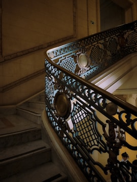 Elegant staircase with marble steps and wrought iron railing.