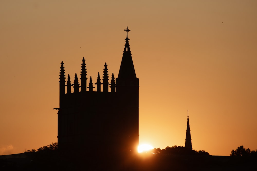 Il sole sta tramontando dietro un campanile della chiesa