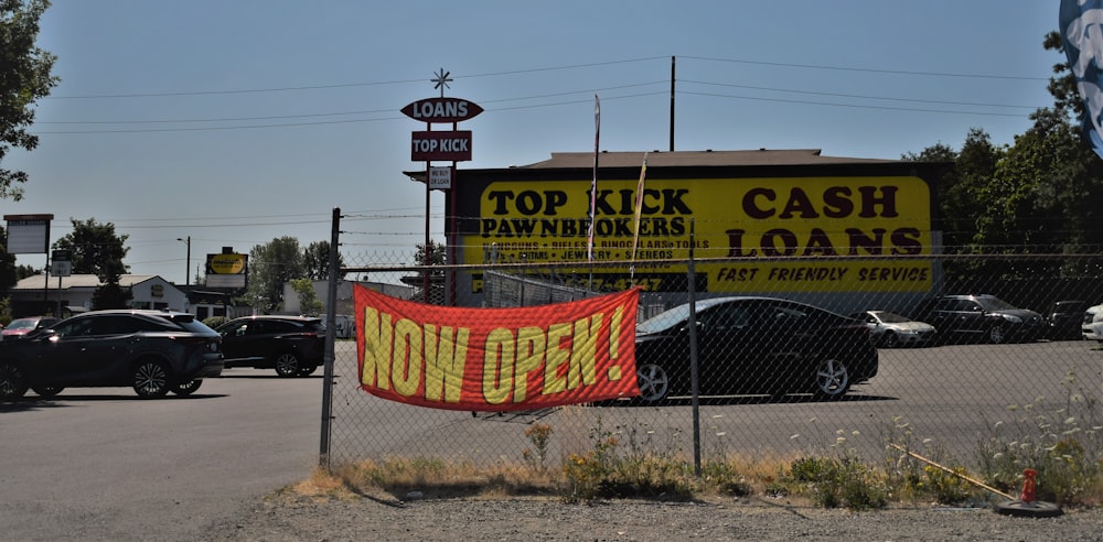 a sign on a chain link fence in front of a business