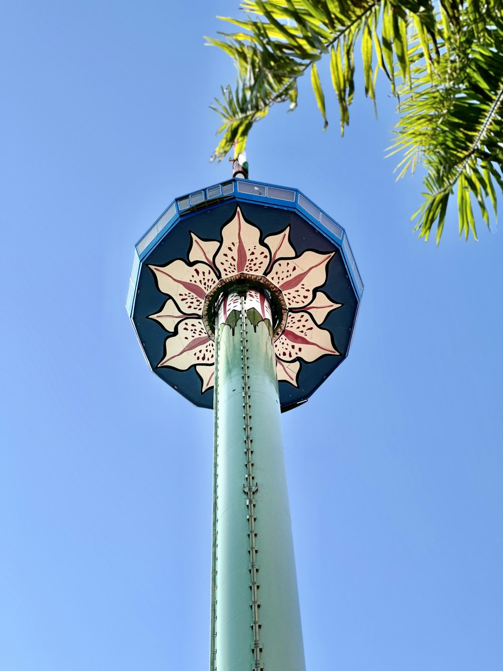 un grand poteau avec un parapluie coloré sur le dessus