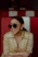 a woman wearing sunglasses sitting in a booth