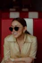 a woman wearing sunglasses sitting in a booth