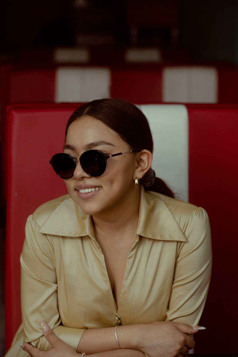 a woman wearing sunglasses sitting in a booth