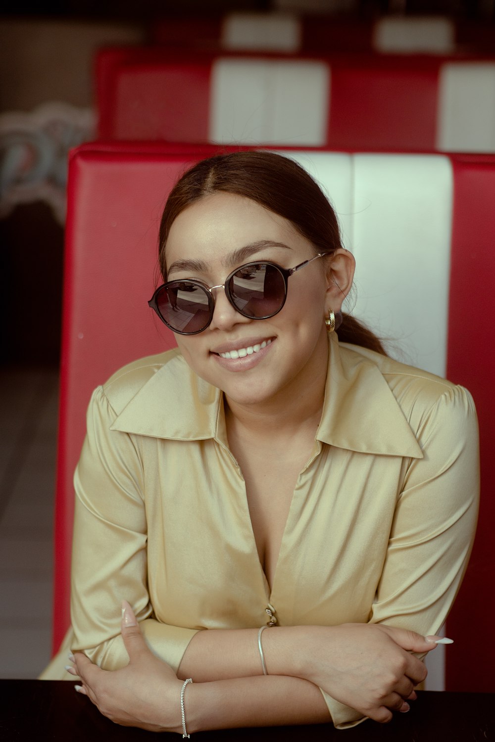 a woman wearing sunglasses sitting at a table