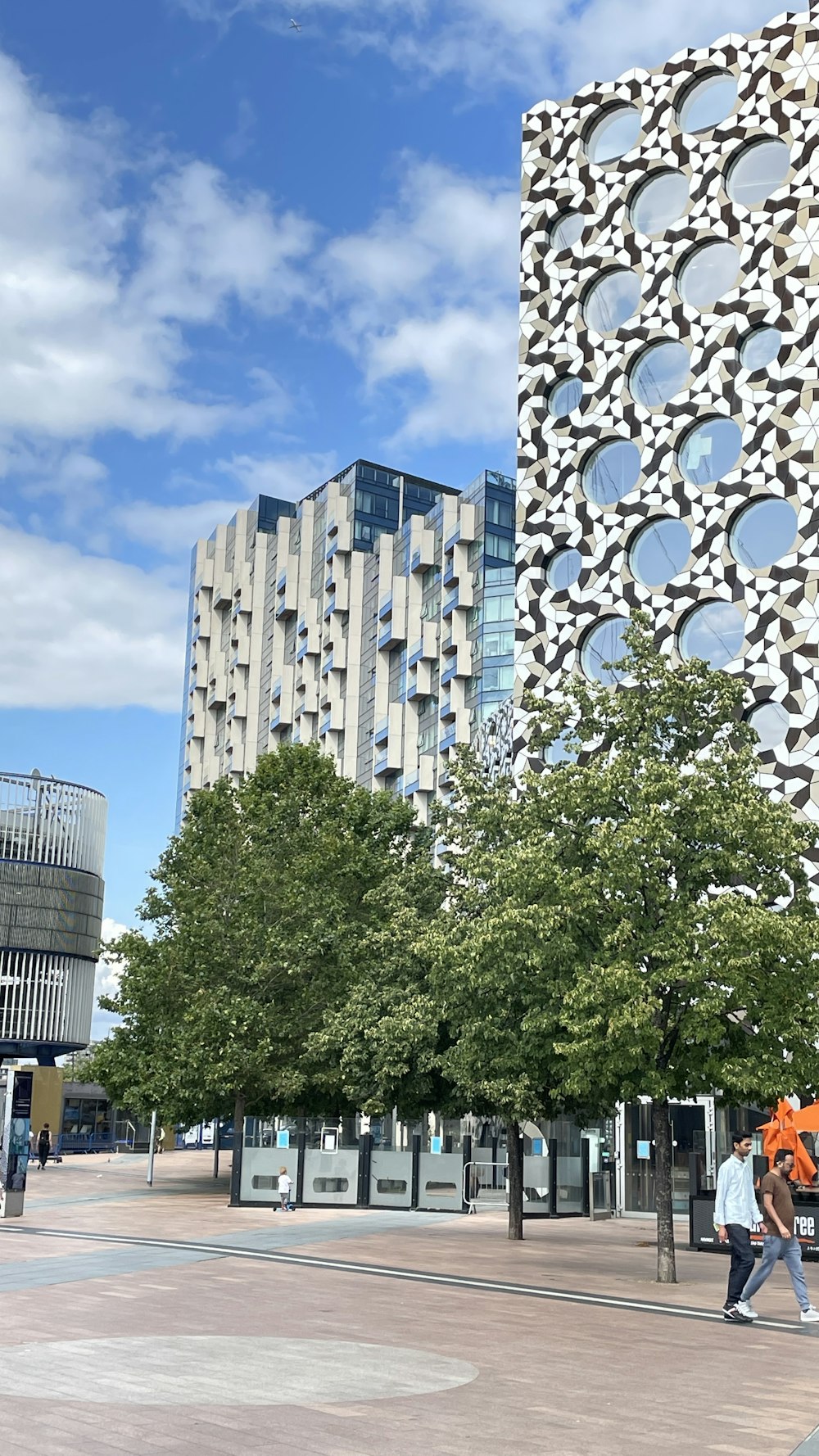 a couple of people walking down a street next to a tall building