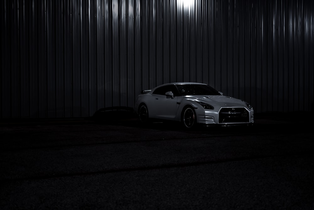 a car parked in front of a building in the dark