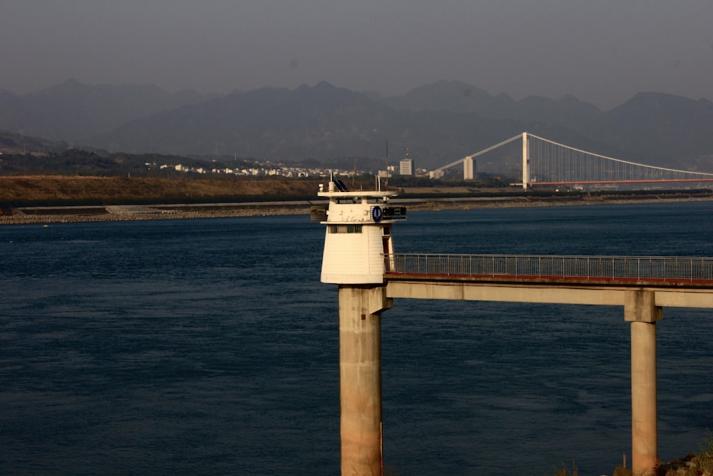 a bridge over a body of water with mountains in the background