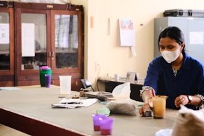 a woman wearing a face mask sitting at a table