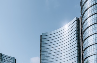 Close-up of sleek glass façades reflecting the Dubai skyline on a sunny day.