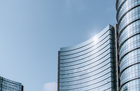 Close-up of sleek glass façades reflecting the Dubai skyline on a sunny day.