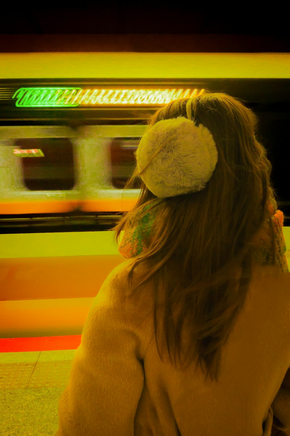 a woman is waiting for a train at the station