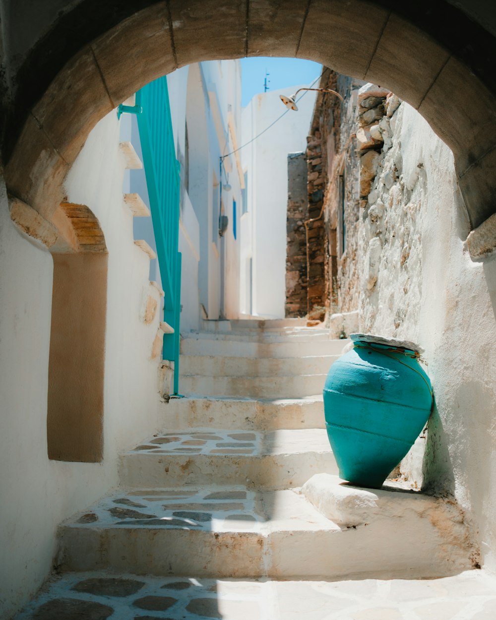 a blue vase sitting on the steps of a building