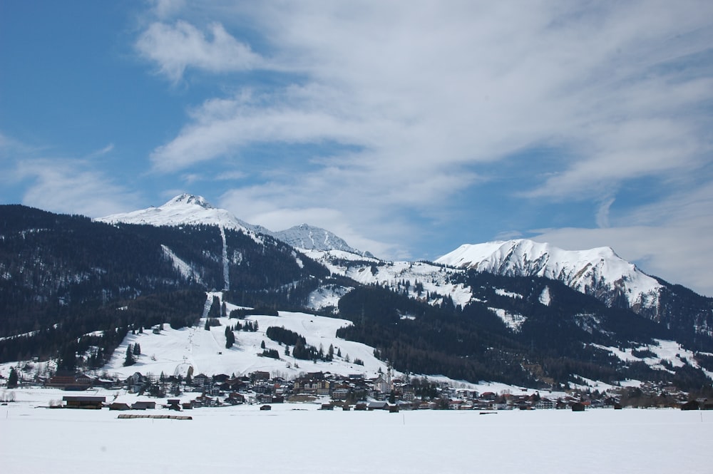 a snow covered mountain with a village in the foreground