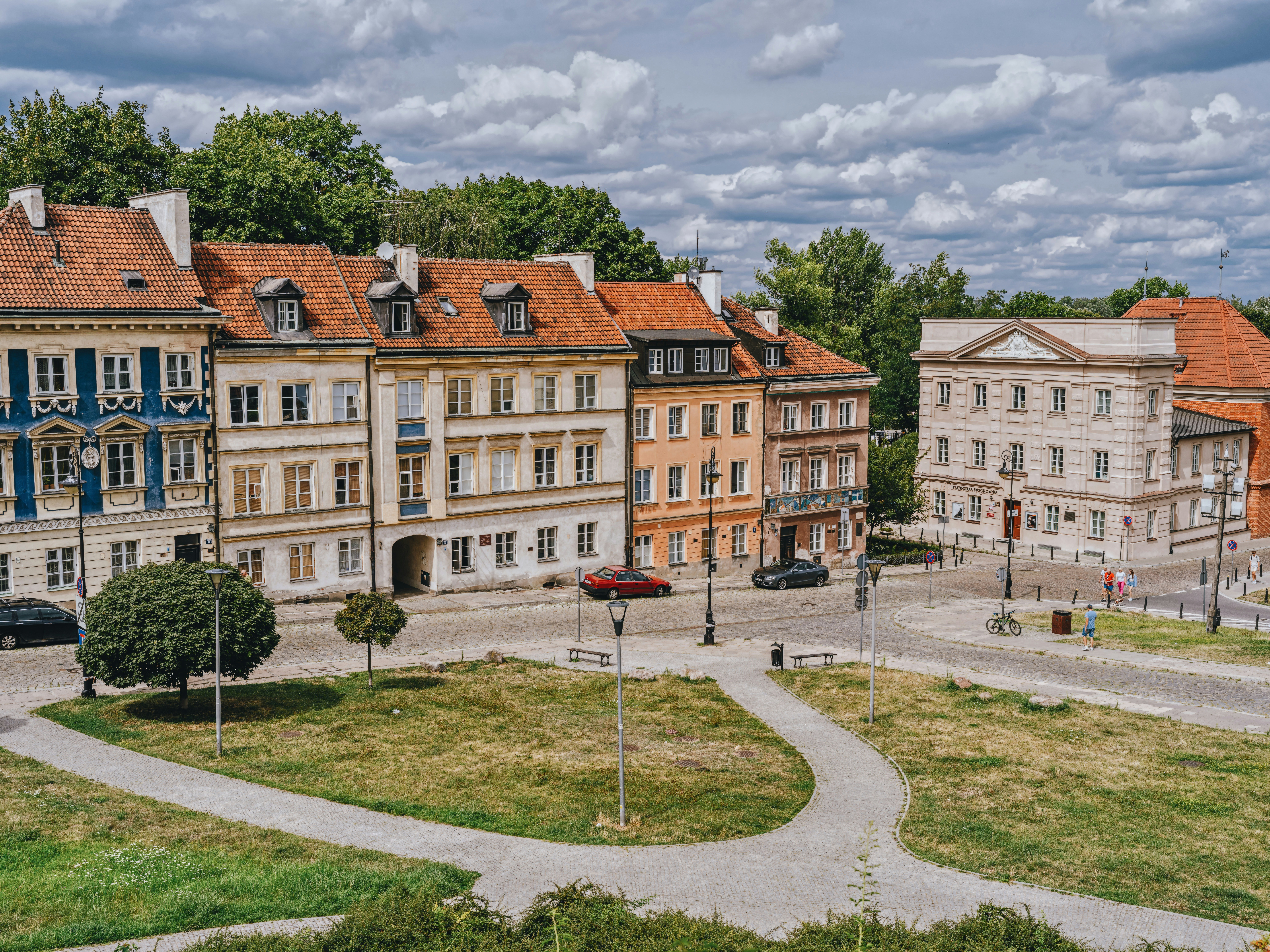 a group of buildings sitting on top of a lush green field