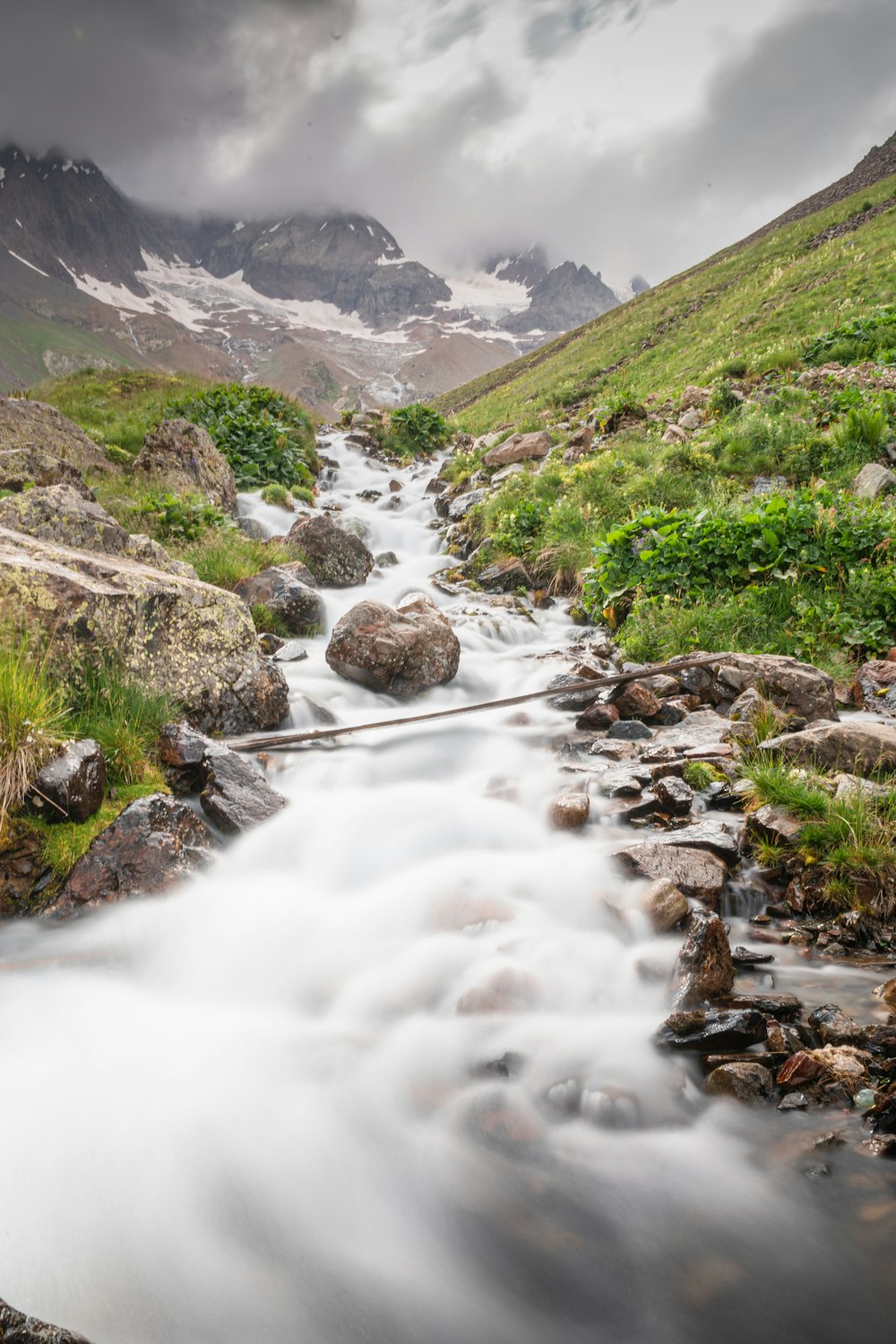 a stream running through a lush green valley