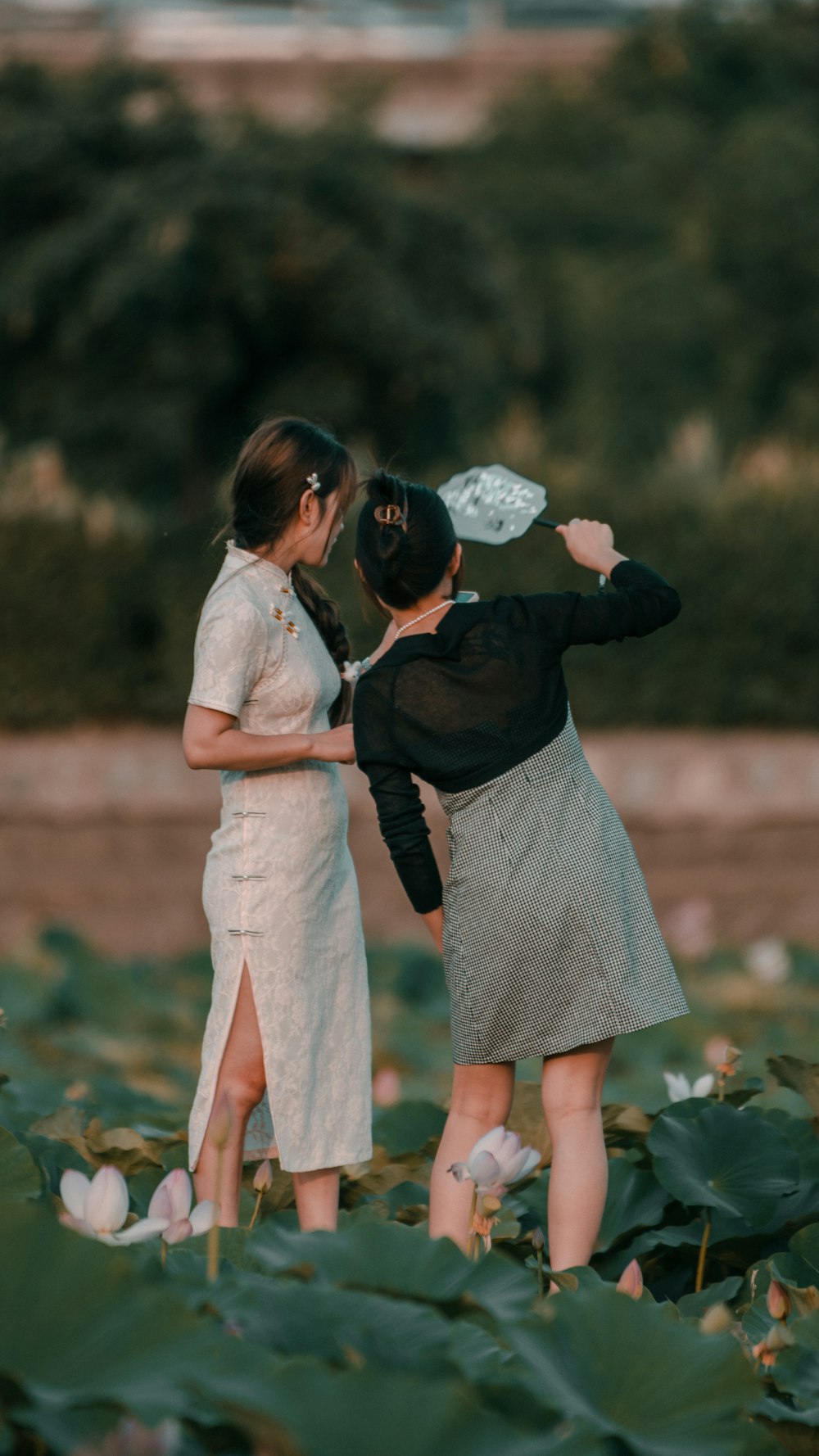 a couple of women standing next to each other in a field