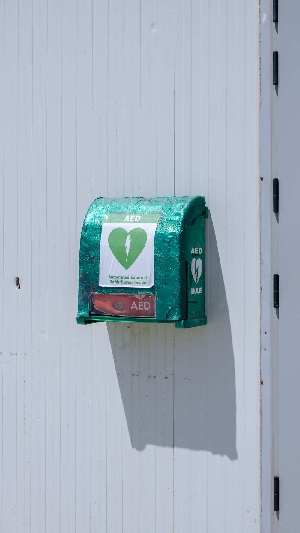 a green mailbox attached to a white wall