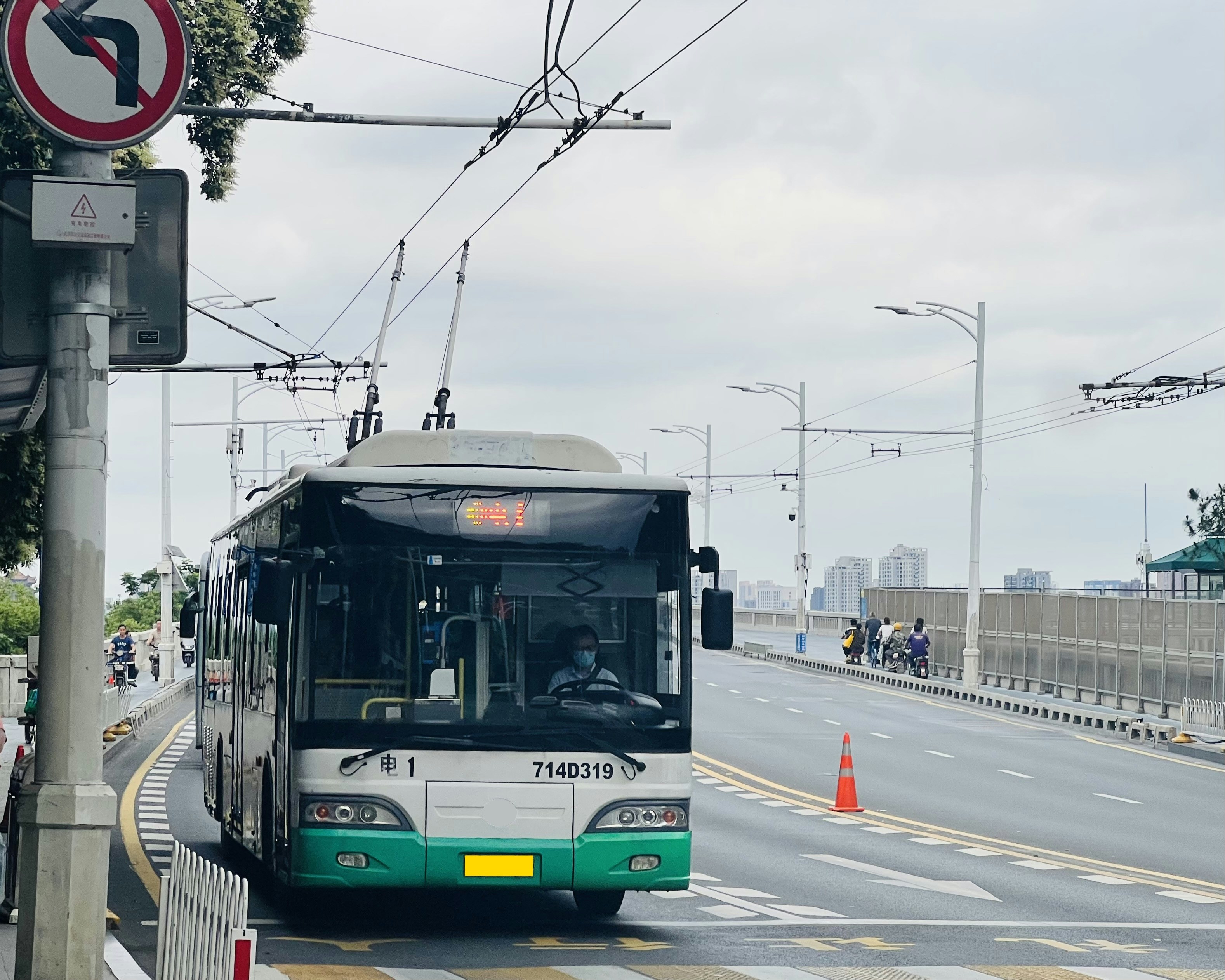 a green and white bus driving down a street