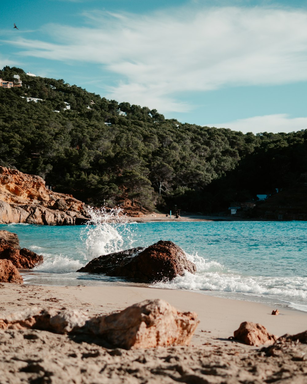 Una playa con rocas y agua salpicando en ella