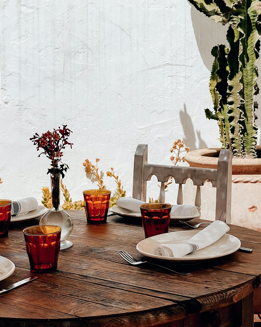 a wooden table topped with plates and glasses