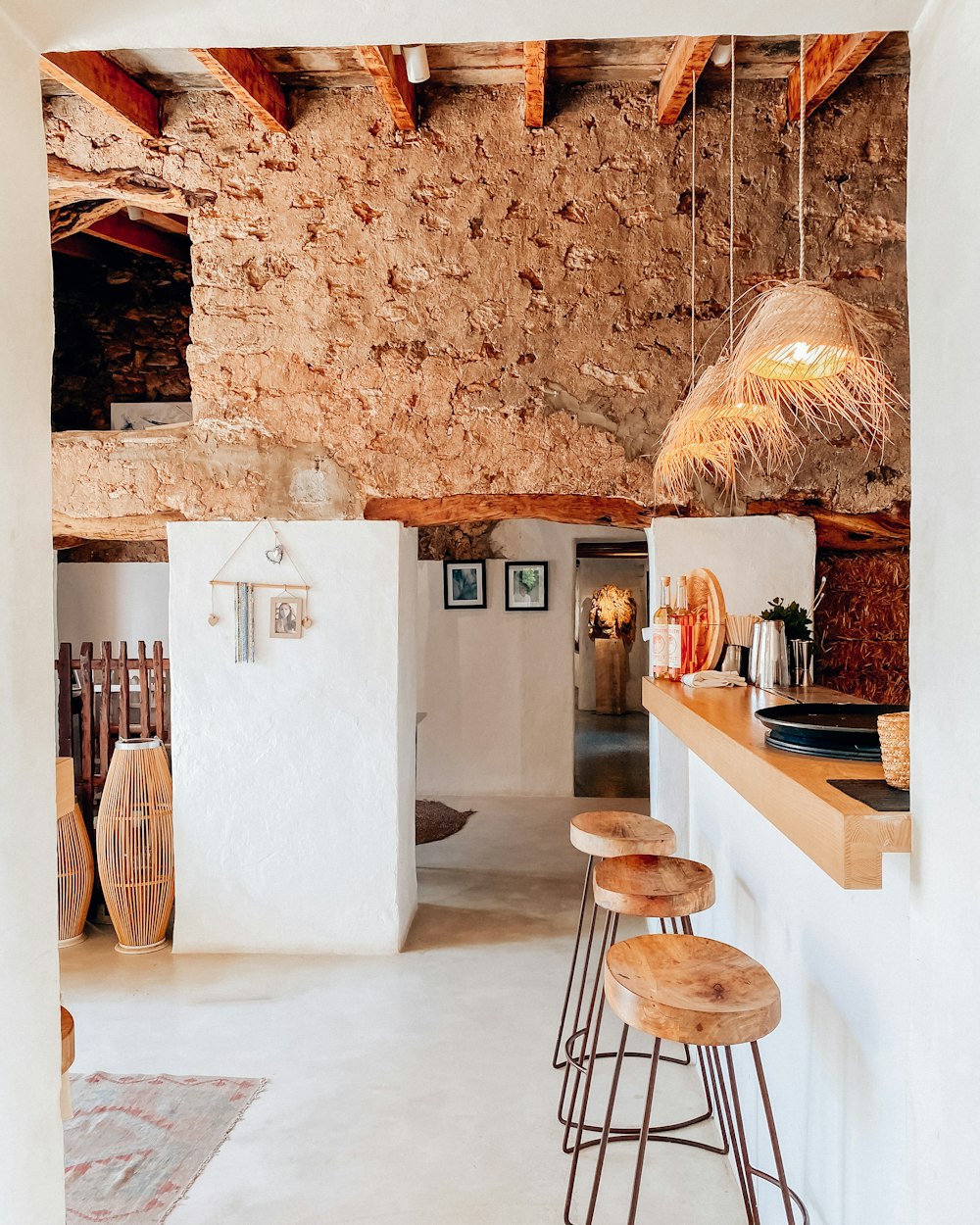 a kitchen area with stools and a counter