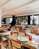 Cozy interior of Fuego Blanco with red and white decor and wooden tables set for guests.
