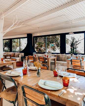 Cozy interior of Fuego Blanco with red and white decor and wooden tables set for guests.