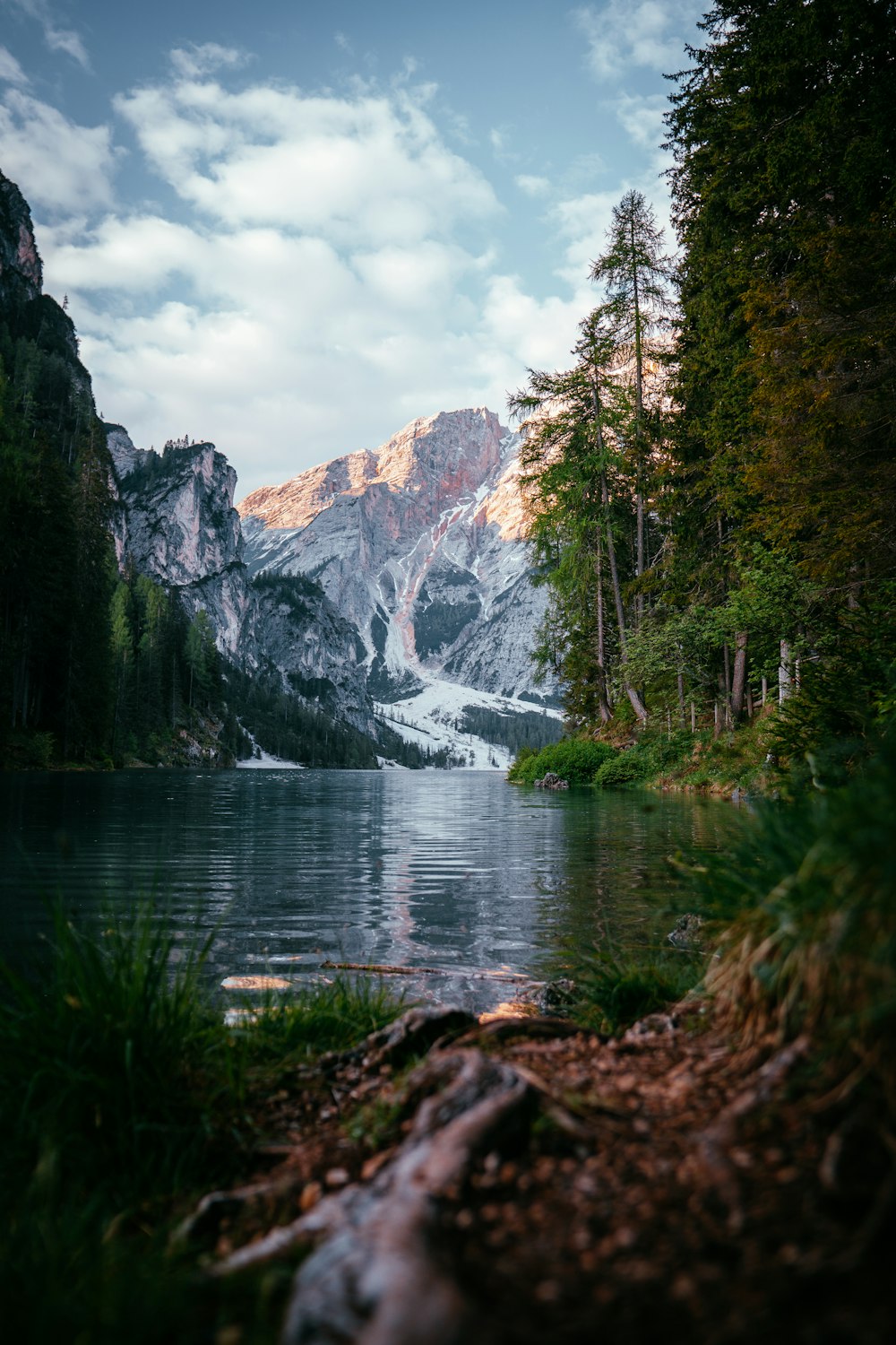 um corpo de água cercado por árvores e montanhas
