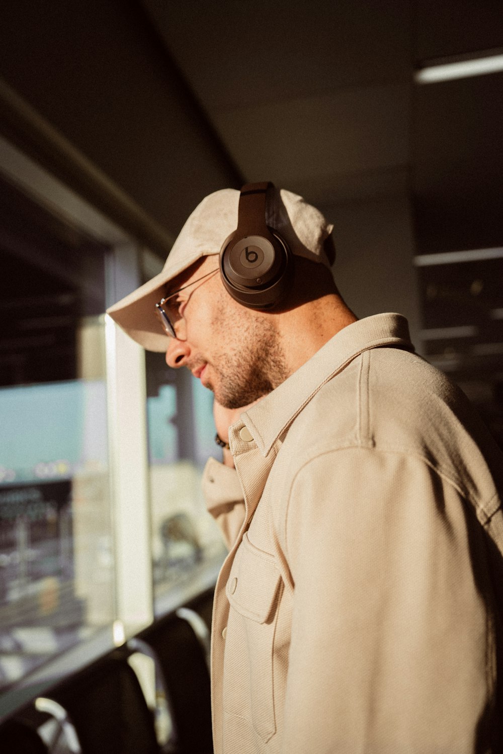 a man wearing headphones while standing next to a window