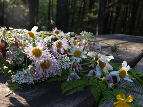 A close-up of a vibrant bouquet of wildflowers artfully arranged on a marble table, sunlight casting soft shadows.
