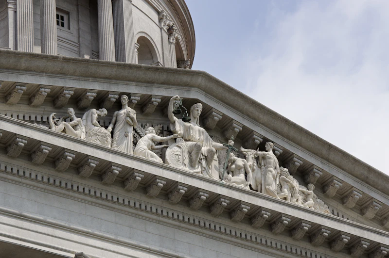 Neoclassical courthouse building with a statue depicting the allegory of justice
