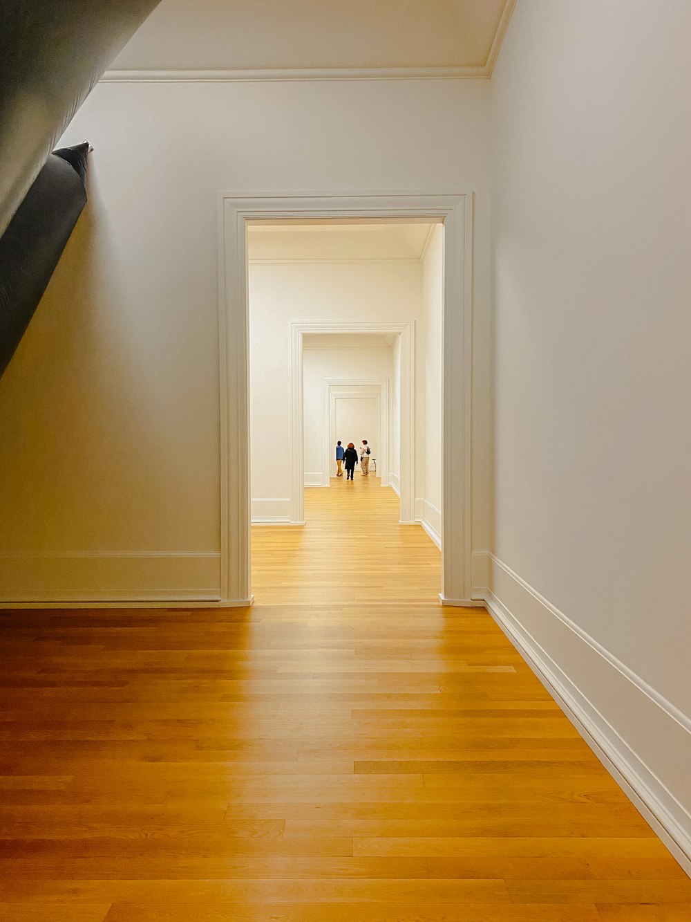 two people walking down a long hallway in a building