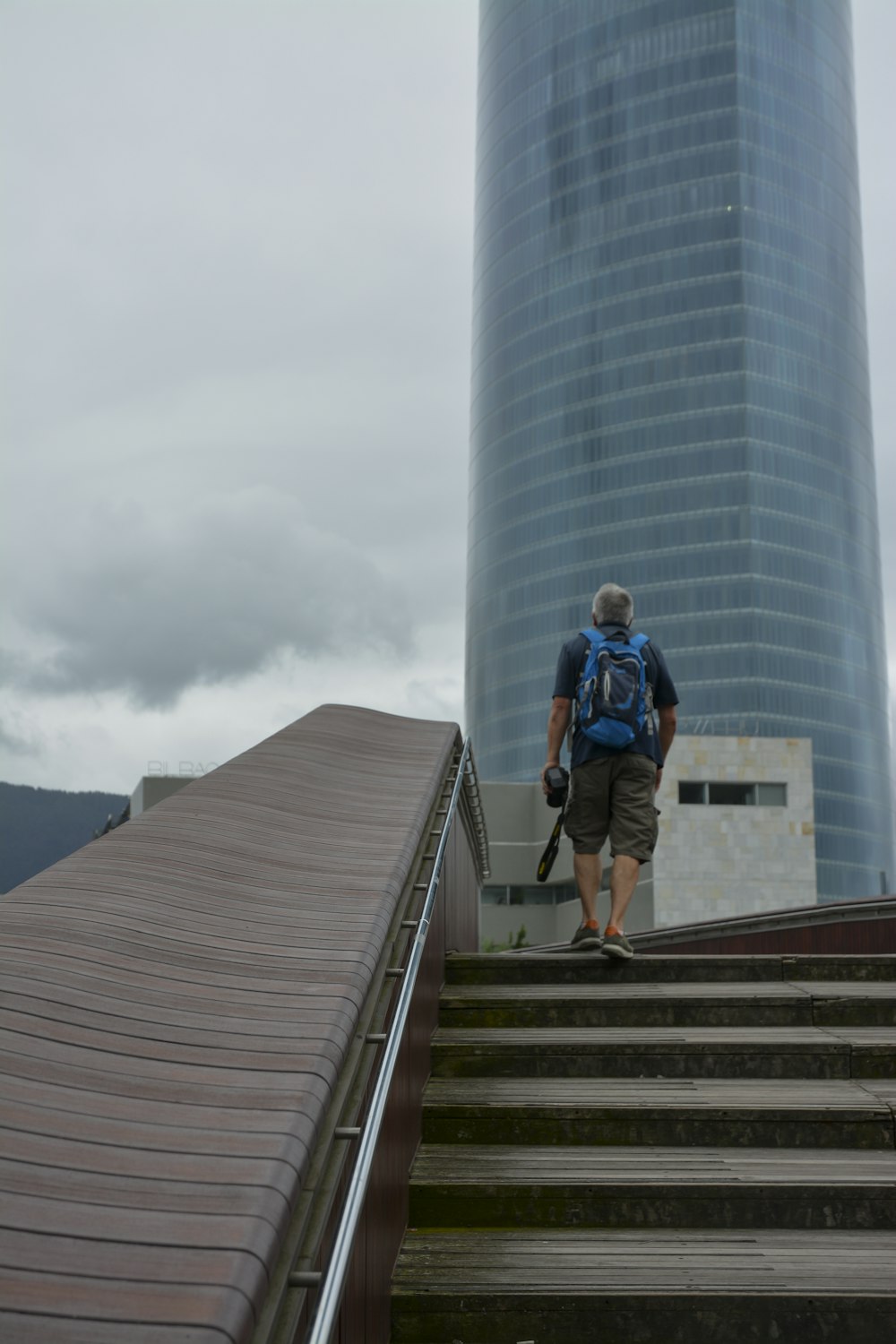 a man with a backpack walking up a flight of stairs