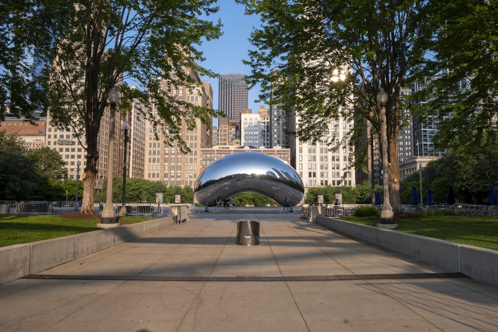 a large metal object sitting in the middle of a park