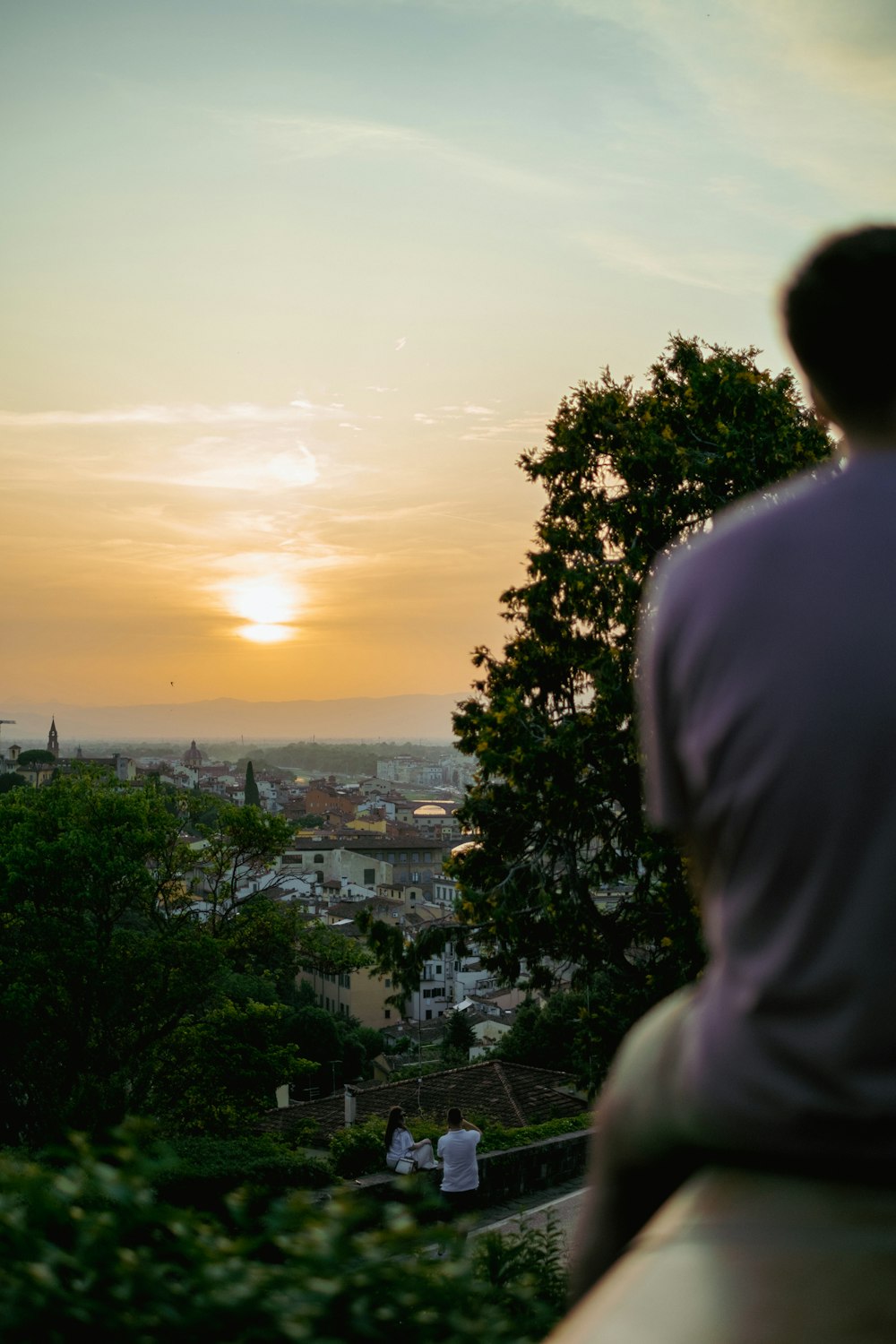 a man sitting on a bench watching the sunset