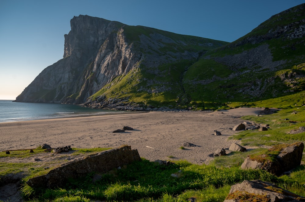 a sandy beach next to a large mountain