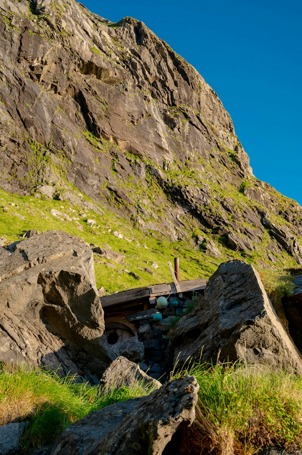 a mountain side with rocks and grass on the ground