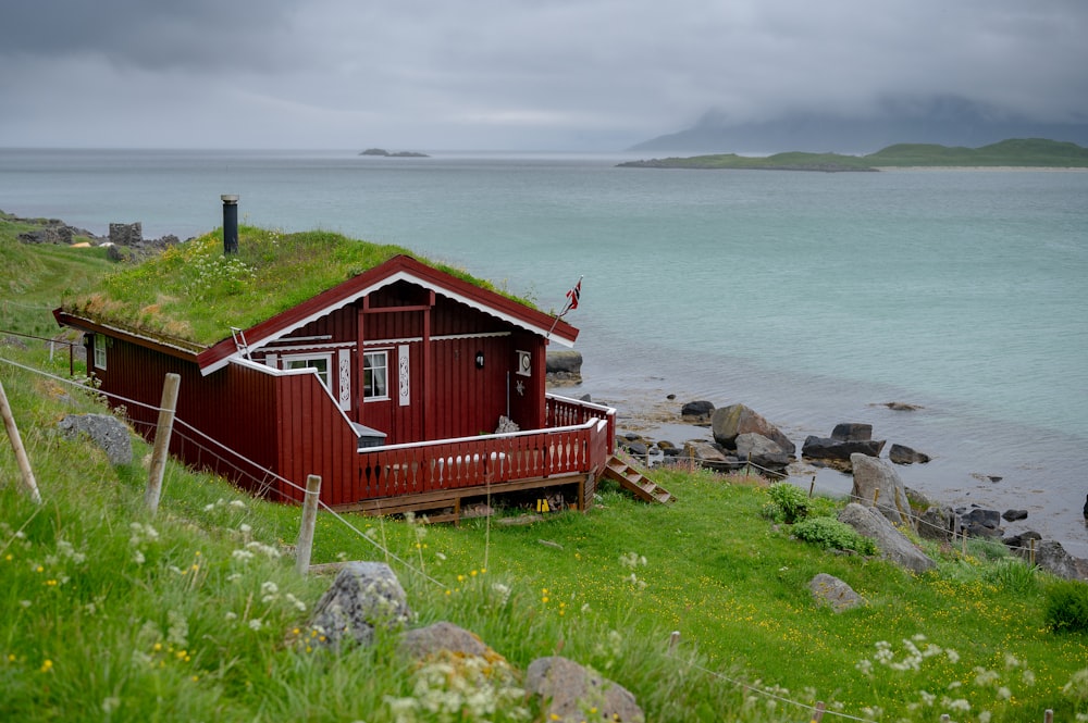 a small red house with a grass roof