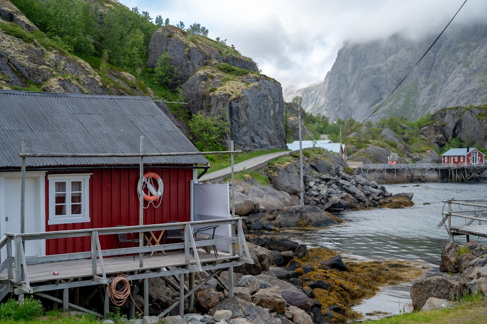 a red house sitting next to a body of water