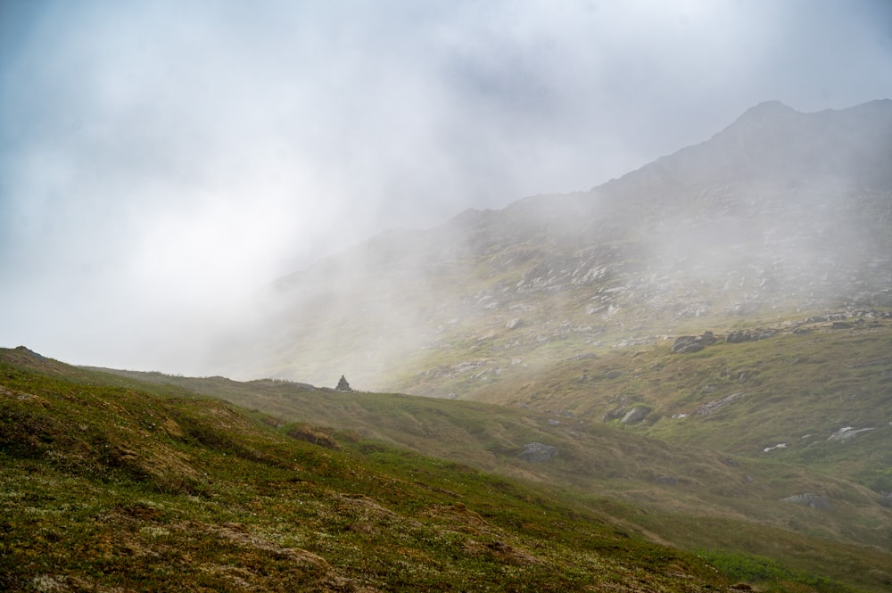 a person walking up a hill on a foggy day