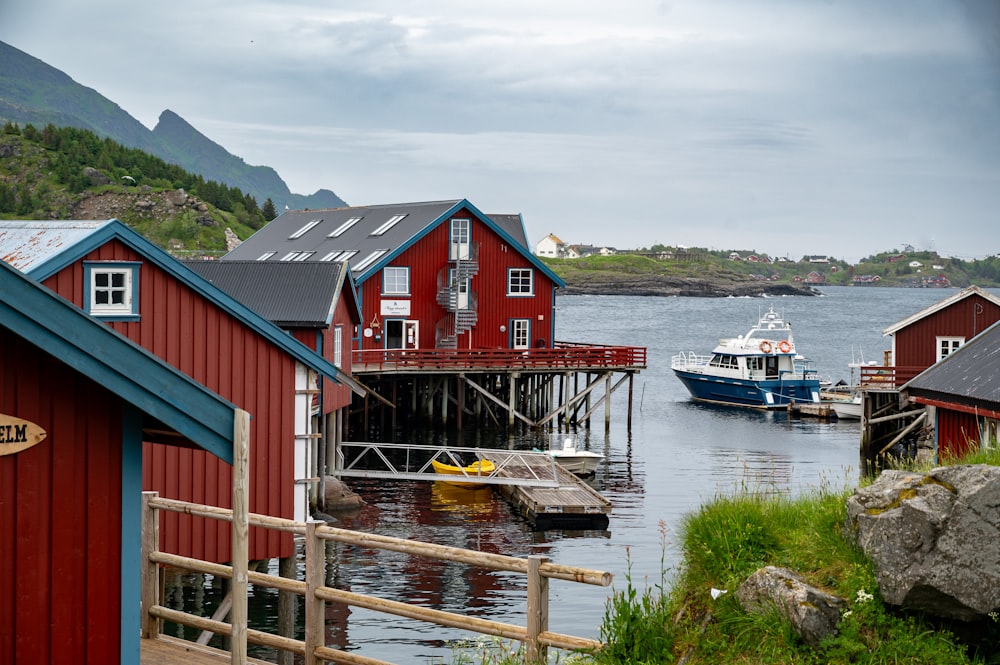 a group of red houses sitting next to a body of water