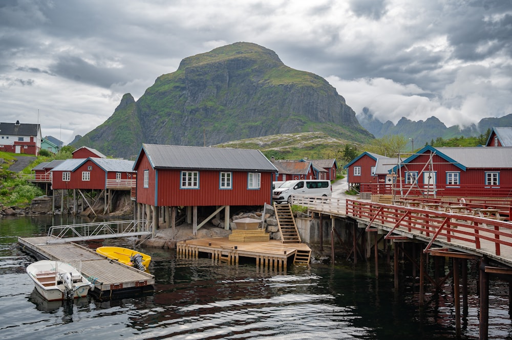 un muelle con un barco y algunas casas rojas